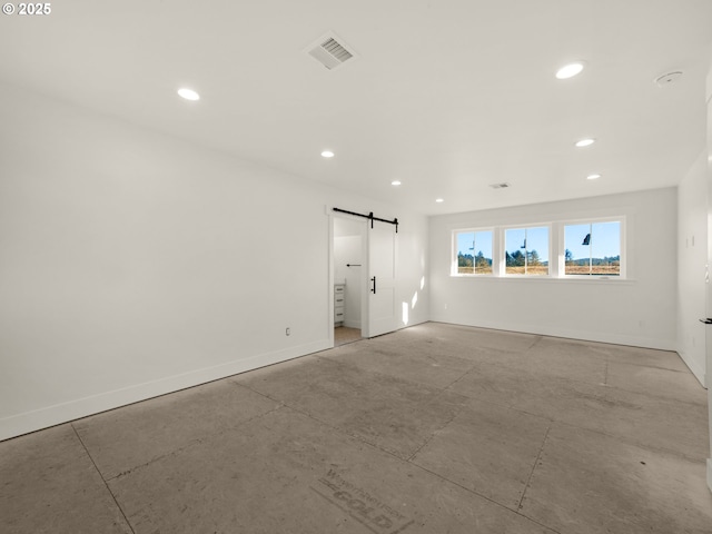 unfurnished room with a barn door