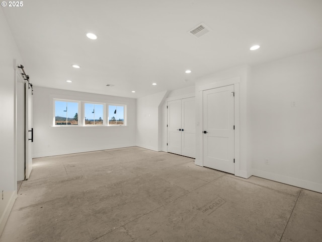 unfurnished room with a barn door