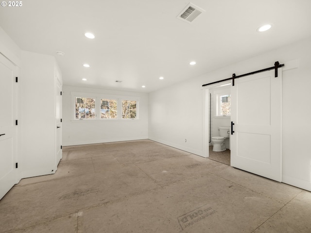 unfurnished room with a barn door