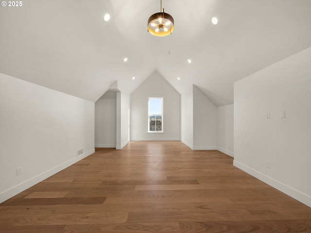 additional living space with lofted ceiling and light hardwood / wood-style floors