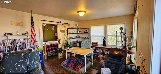 office with a barn door and wood finished floors