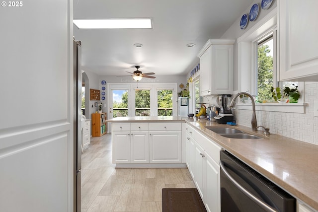 161 Single Pine Ln, Winchester, OR 97495 - kitchen featuring stainless steel dishwasher, a peninsula, decorative backsplash, white cabinets, and a ceiling fan