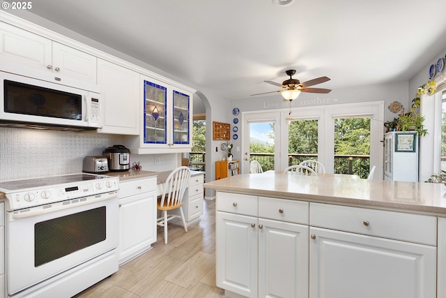 161 Single Pine Ln, Winchester, OR 97495 - kitchen with white appliances, decorative backsplash, white cabinets, glass insert cabinets, and a ceiling fan