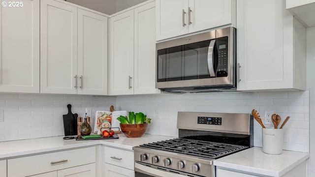 6558 SE Nasha St, Hillsboro, OR 97123 - kitchen featuring appliances with stainless steel finishes, white cabinets, light countertops, and tasteful backsplash