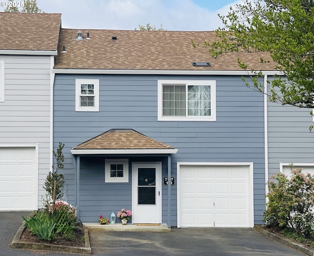 7197 SW Sagert St Unit 103, Tualatin, OR 97062 - view of front facade featuring driveway, a shingled roof, and an attached garage