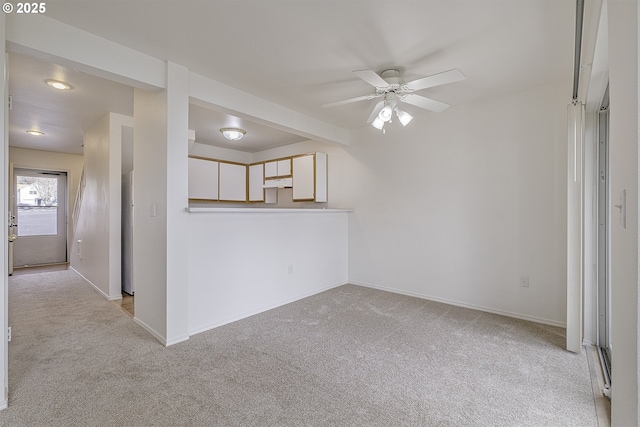 7197 SW Sagert St Unit 103, Tualatin, OR 97062 - spare room featuring light carpet, a ceiling fan, and baseboards