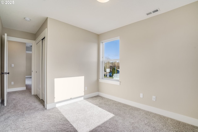 carpeted spare room with baseboards and a smoke detector