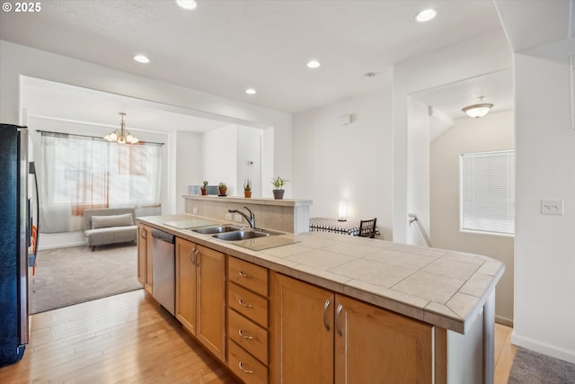 kitchen with sink, hanging light fixtures, a center island with sink, appliances with stainless steel finishes, and light hardwood / wood-style floors