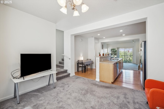 carpeted living room featuring an inviting chandelier and sink