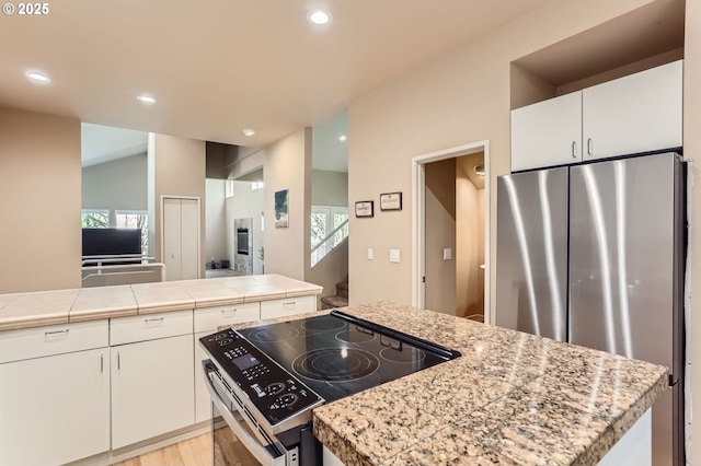 kitchen featuring light countertops, white cabinets, light wood finished floors, stainless steel appliances, and recessed lighting