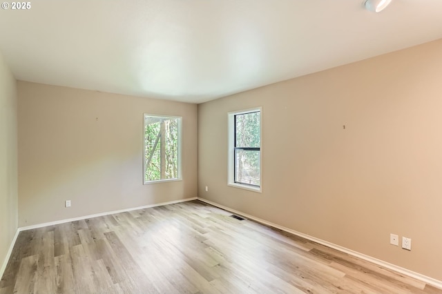 empty room featuring baseboards and light wood-style flooring