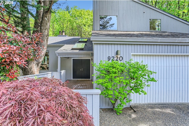 entrance to property featuring a shingled roof