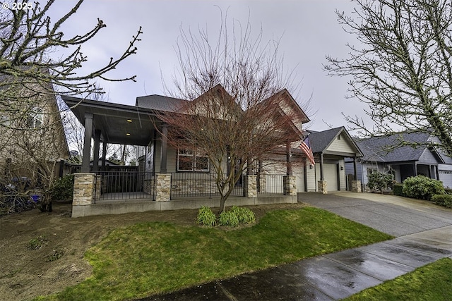 view of front facade featuring concrete driveway, an attached garage, a front yard, fence, and stone siding