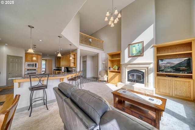 living room with light colored carpet, a high ceiling, and a chandelier