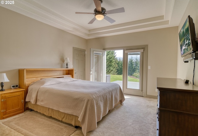 bedroom featuring access to outside, ceiling fan, light colored carpet, and a raised ceiling