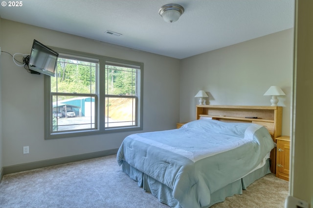 bedroom with visible vents, baseboards, and light colored carpet