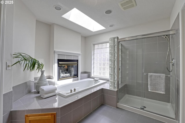 15017 SW Telluride Ter, Beaverton, OR 97007 - full bath featuring a skylight, a garden tub, a stall shower, tile patterned flooring, and a fireplace