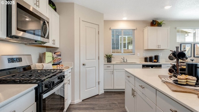 2906 U St, Springfield, OR 97477 - kitchen with stainless steel appliances, dark wood-style flooring, white cabinets, a sink, and recessed lighting