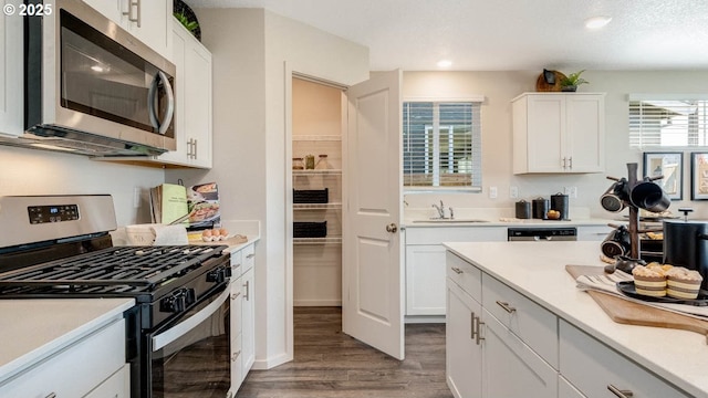 2906 U St, Springfield, OR 97477 - kitchen with stainless steel appliances, wood finished floors, light countertops, white cabinetry, and recessed lighting