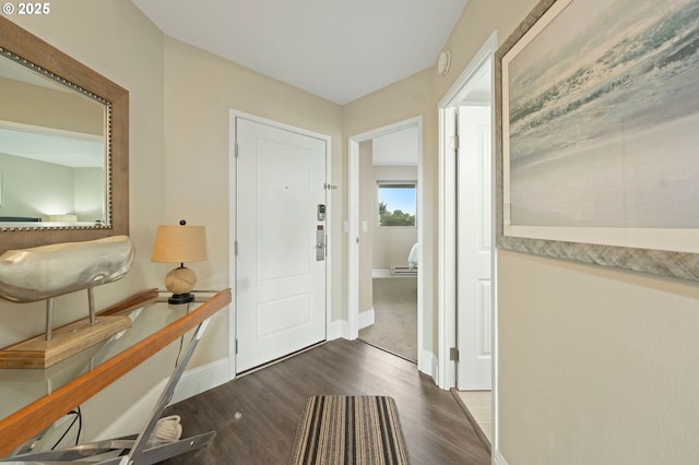 entrance foyer with dark wood-style floors and baseboards