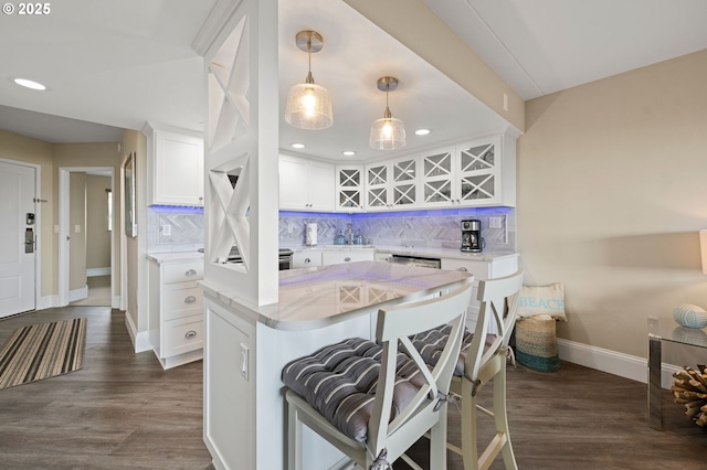 kitchen featuring tasteful backsplash, dark wood finished floors, and white cabinets