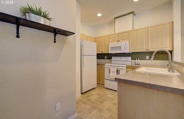 kitchen featuring recessed lighting, white appliances, a sink, baseboards, and light brown cabinetry