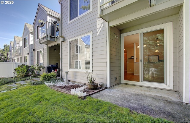 property entrance featuring a yard, a patio area, and fence