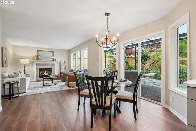 7330 SW Kelsi Ct, Portland, OR 97223 - dining room with healthy amount of natural light, a stone fireplace, a chandelier, and dark wood-style floors
