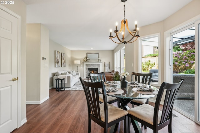 7330 SW Kelsi Ct, Portland, OR 97223 - dining space with dark wood-type flooring, a stone fireplace, a chandelier, and baseboards