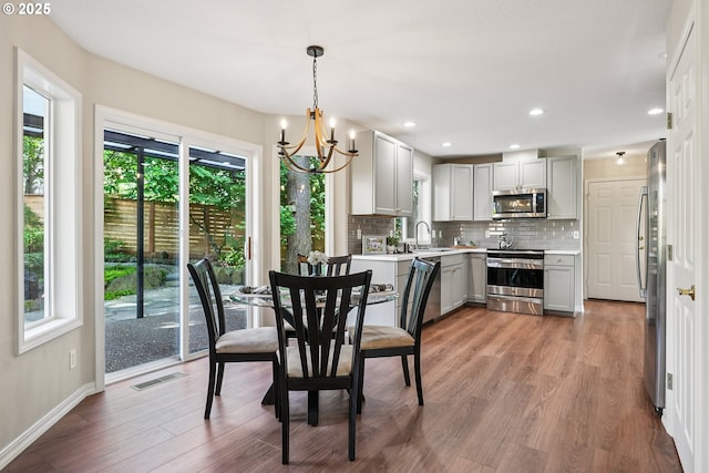 7330 SW Kelsi Ct, Portland, OR 97223 - dining room featuring a chandelier, healthy amount of natural light, baseboards, light wood-type flooring, and recessed lighting