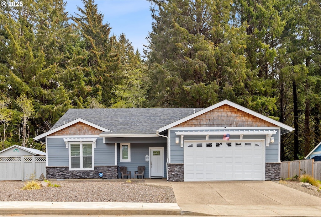 2969 NE 61st Pl, Lincoln City, OR 97367 - craftsman-style house featuring stone siding, an attached garage, and concrete driveway