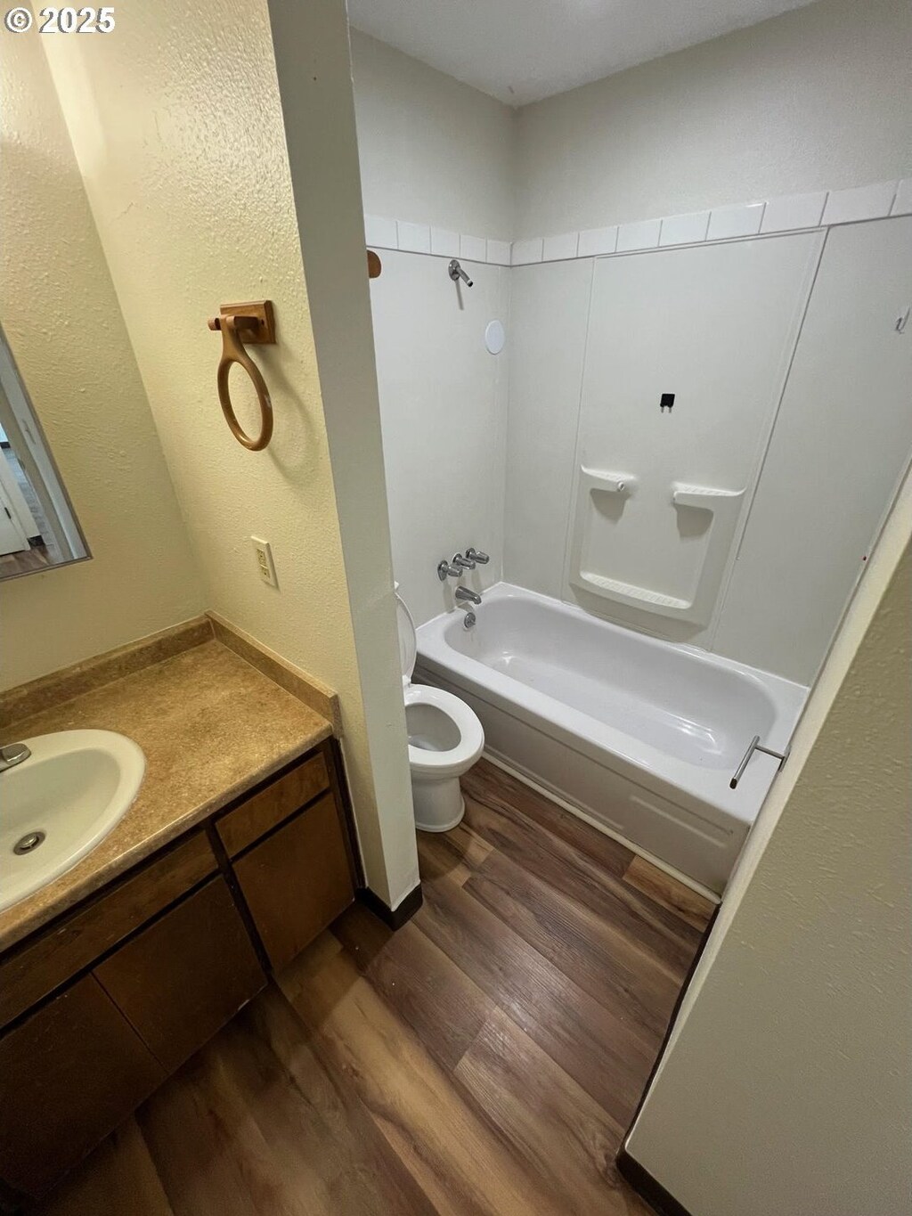 full bath with toilet, shower / washtub combination, wood finished floors, and vanity