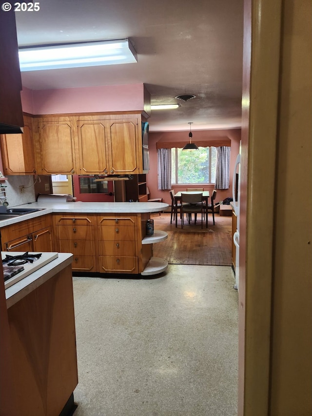 28213 Hunter Creek Hts, Gold Beach, OR 97444 - kitchen featuring a peninsula, light countertops, and brown cabinets