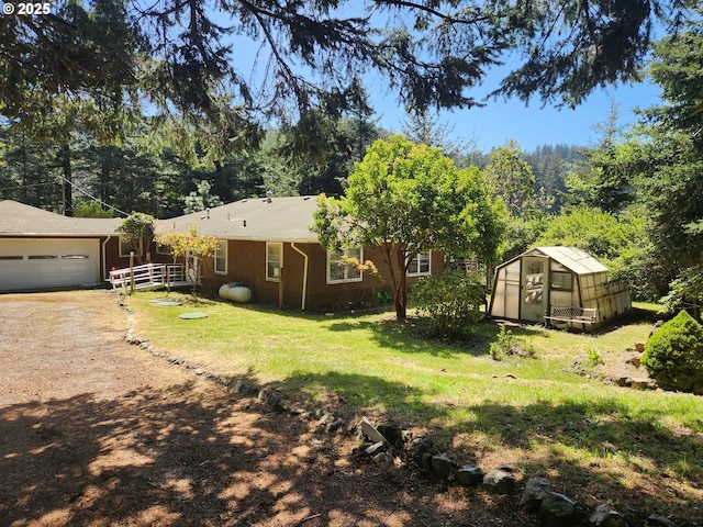 28213 Hunter Creek Hts, Gold Beach, OR 97444 - exterior space featuring a garage, a lawn, a greenhouse, an outdoor structure, and dirt driveway