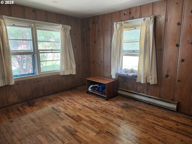 28213 Hunter Creek Hts, Gold Beach, OR 97444 - unfurnished room with baseboard heating, wood walls, and wood-type flooring