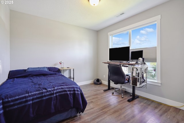 1522 NE Sunrise Ln, Hillsboro, OR 97124 - bedroom with baseboards, multiple windows, wood finished floors, and visible vents