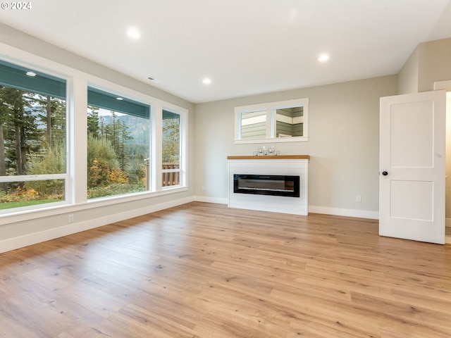 unfurnished living room featuring a healthy amount of sunlight and light hardwood / wood-style floors