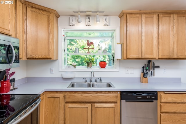 kitchen with stainless steel appliances, a sink, and light countertops