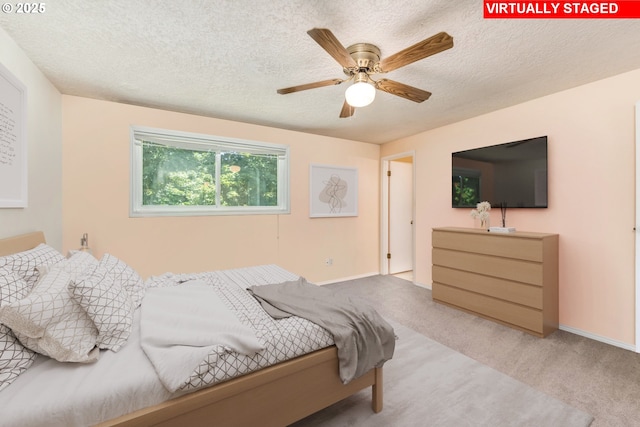 carpeted bedroom featuring a textured ceiling, a ceiling fan, and baseboards