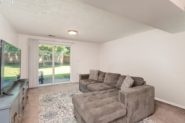 carpeted living room featuring visible vents, baseboards, and a textured ceiling