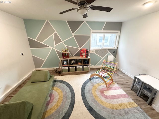 playroom featuring ceiling fan, baseboards, and wood finished floors