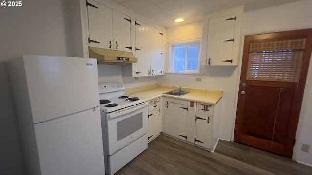 kitchen featuring white appliances, dark wood-style floors, light countertops, under cabinet range hood, and a sink