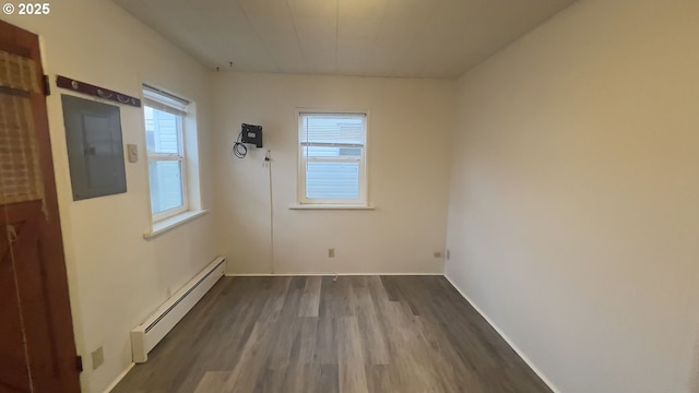 empty room featuring baseboards, electric panel, dark wood finished floors, and baseboard heating