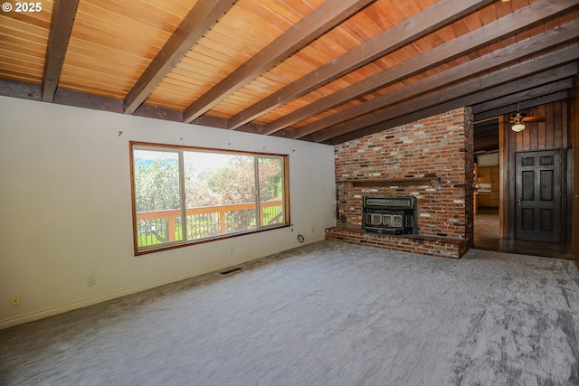 unfurnished living room with carpet flooring, vaulted ceiling with beams, visible vents, wooden ceiling, and a wood stove