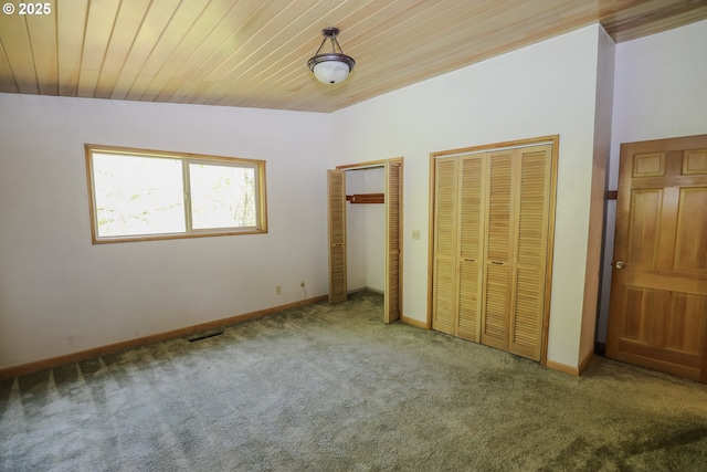 unfurnished bedroom featuring two closets, baseboards, wood ceiling, and carpet flooring