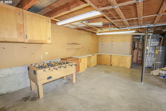 unfinished basement with strapped water heater and a workshop area