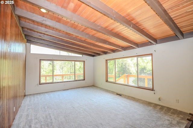 unfurnished room featuring carpet, visible vents, baseboards, lofted ceiling with beams, and wood ceiling