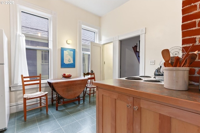 kitchen featuring dark tile patterned flooring and white appliances