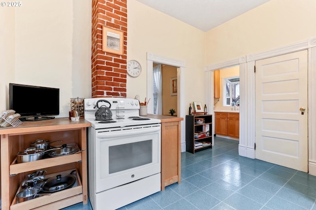 kitchen with dark tile patterned flooring and electric range