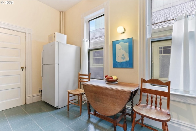 kitchen with white fridge and tile patterned floors